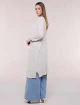 Cardigan largo de punto liviano y suave, de color blanco, con diseño abierto al frente, mangas largas con puños acanalados y bolsillos frontales aplicados.