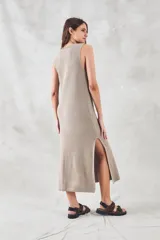 Vestido midi sin mangas, confeccionado en tejido de punto de algodón con textura tipo waffle. Presenta un corte recto, cuello redondo y aberturas laterales pronunciadas en el ruedo.