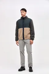 Campera de estilo outdoor con diseño de bloques de color, confeccionada en una combinación de sherpa y paneles de nylon capitoneado. Presenta cierre frontal con botones a presión, cuello alto, bolsillos laterales y un bolsillo en el pecho con cierre. Incluye puños elásticos y detalles bordados en la manga.