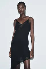 Vestido midi de estilo lencero confeccionado en viscosa, con escote en pico, tirantes finos y detalle de encaje a tono. Presenta un diseño con bajo asimétrico.