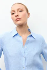 Camisa de lino color celeste melange, de corte clásico con cuello camisero y manga larga.