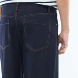 Jean baggy azul oscuro de corte relajado, con diseño clásico de cinco bolsillos y costuras en contraste.