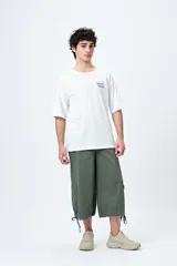 Remera color beige con cuello redondo y mangas cortas. Estampado pequeño en el frente con la frase "Spritz and Shine".