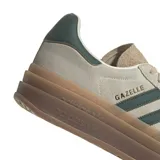 Championes adidas Gazelle Bold de diseño urbano con plataforma, confeccionados en gamuza color beige con las icónicas tres tiras laterales en verde oscuro. Presentan detalles en cuero en el talón y suela de goma con relieve.