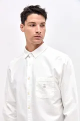Camisa de corte regular fit confeccionada en algodón, con cuello clásico, cierre frontal de botones y bolsillo en el pecho con detalle bordado.