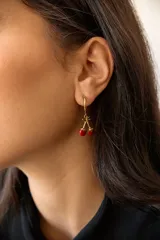 Aros de acero quirúrgico hipoalergénico, con argolla pequeña y dije colgante en forma de cerezas.