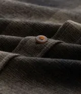 Camisa de manga larga con diseño de cuadros en tonos marrones, confeccionada en algodón. Presenta cuello camisero, cierre frontal con botones y un bolsillo en el pecho con botón.