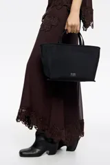 Bolso de mano Bimba y Lola de tamaño mediano, con estructura blanda, doble asa de mano y asa regulable de tejido. Cuenta con cierre de cremallera, detalles metálicos y logo de la marca en el frente.