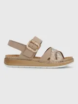 Sandalia de plataforma baja color beige con tiras cruzadas, una de ellas con acabado texturizado brillante. Presenta una tira ajustable con hebilla decorativa y cierre de velcro, sobre una suela de estilo yute con base de poliuretano.
