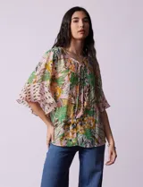 Blusa de gasa estampada con cuello a la base y lazo. Tiene plisado en la delantera, detalles de brillo en lurex, abertura central con botones y mangas 3/4 fluidas.