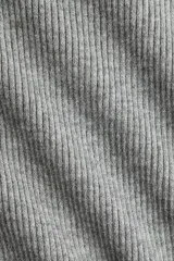 Top entallado largo en punto acanalado suave, de color gris, con escote bote y mangas largas con abertura en los puños.