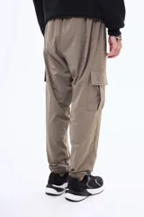 Pantalon cargo negro de corte holgado, con bolsillos laterales con solapa y puños elásticos en los tobillos. Cuenta con cintura elástica con cordón de ajuste.