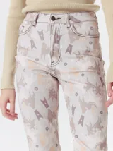 Pantalón de jean con tiro medio y corte de pierna recta. Presenta una estampa exclusiva con motivos geométricos y figuras abstractas en tonos beige y marrón claro, con costuras a contratono.