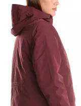 Campera 3 en 1 de color beige, con sistema de capas desmontables. La capa exterior es de tejido técnico resistente al viento y lluvia ligera, con capucha fija, cierre frontal con solapa, bolsillos de parche y ajuste elástico interno en la cintura. Incluye una campera interior capitoneada ultraliviana que puede usarse de forma independiente.