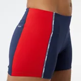 Calza corta de running azul marino con una franja vertical naranja y blanca en el lateral.