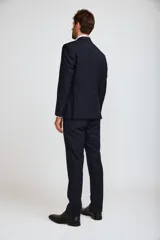 Traje completo de tres piezas en color azul marino, compuesto por saco entallado, chaleco abotonado y pantalón de vestir de corte recto.