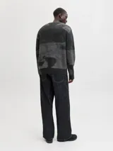 Sweater de punto con diseño de bloques de color en tonos grises y negros, manga larga, cuello redondo y ajuste relajado. Presenta puños y cuello acanalados con una textura suave y elástica.