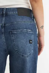 Jean azul de tiro alto, corte recto y pierna ancha.