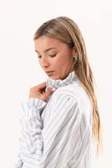 Camisa de manga larga con diseño a rayas celestes y blancas, cuello alto y detalle de volados en la cartera frontal y los puños.
