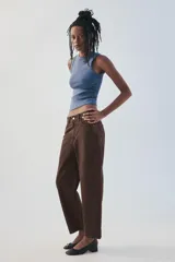 Jeans de tiro medio color marrón con diseño de volumen crop, silueta holgada en las piernas y cinco bolsillos tradicionales. Cierre frontal con cremallera y botón metálico.