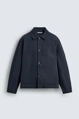 Sobrecamisa de corte relajado confeccionada en tejido de algodón con estructura canvas y efecto lavado. Presenta cuello solapa, cierre frontal con botones, mangas largas con puños abotonados y tres bolsillos frontales de plastrón.