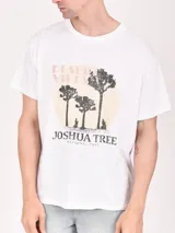 Remera blanca de algodón con estampado frontal de tres árboles de Josué en un círculo amarillo y texto "Desert Vibes" y "Joshua Tree National Park".