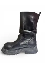 Bota alta de cuero marrón con suela track gruesa, detalles de hebillas metálicas en el empeine y botones decorativos en la caña.