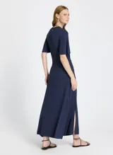 Vestido largo azul marino de punto ligero, con escote redondo, mangas cortas, abertura lateral y detalle de botones dorados en el lateral.