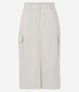 Falda midi color crema, de corte recto, con bolsillos laterales y cierre frontal.
