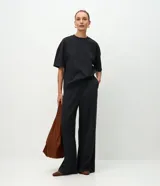 Pantalón wide leg de corte recto y holgado, color gris oscuro, con cintura elástica y costura central vertical en el frente. Confeccionado en una mezcla de poliéster y algodón.