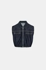 Chaleco de denim oscuro con cuello solapa, cierre frontal con cremallera metálica y bolsillos delanteros con tapeta. Presenta un diseño de corte abullonado con bajo elástico.
