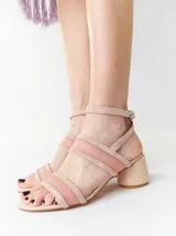 Sandalias de tacón bajo y redondo, con diseño de tiras finas en gamuza y paneles laterales de material translúcido. Cuentan con cierre de pulsera ajustable al tobillo.