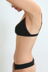 Conjunto de ropa interior compuesto por un corpiño triangular y una bombacha clásica, ambos en color negro con detalles de puntilla en los bordes.