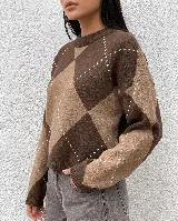 Sweater de punto con diseño de rombos en tonos marrones y beige, cuello redondo y mangas largas con puños acanalados.