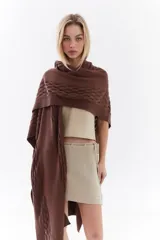 Ruana de punto color beige con detalles texturizados y tramados abiertos, ligera y versátil.