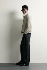 Pantalón relaxed fit negro confeccionado en tejido de algodón con estructura diagonal, estilo de cinco bolsillos y cierre frontal con cremallera y botón metálico.