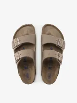 Sandalia tipo zueco Birkenstock modelo Arizona, color marrón topo, con dos tiras ajustables con hebillas metálicas color bronce. Presenta una plantilla anatómica de corcho y goma, y una capa adicional de espuma para mayor confort.