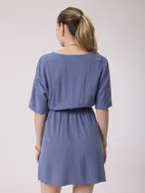 Vestido corto azul con escote en V, mangas cortas y cintura elastizada. Cierre frontal con botones.