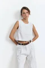Top blanco sin mangas con espalda descubierta y diseño cruzado.