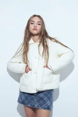 Campera acolchada de color negro con diseño capitoneado, cierre frontal con botones y cuello clásico.