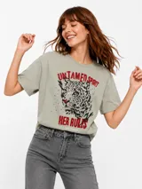 Remera color verde pistacho, de corte boxy y mangas cortas. Presenta una estampa frontal con la ilustración de un leopardo y las leyendas "Untamed Spirit" y "Her Rules" en tonos rojos.