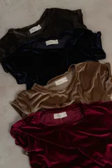 Remera de manga corta confeccionada en terciopelo, con cuello redondo y diseño simple. Una prenda versátil y elegante para elevar cualquier conjunto.