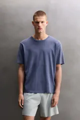 Camiseta de corte regular fit confeccionada en algodón, con cuello redondo y mangas cortas, presentando un acabado de color azul con efecto lavado.