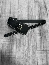 Faja negra de cuero sintético con hebilla metálica dorada y tachas plateadas.