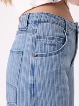 Jean de corte wide leg con diseño de rayas verticales finas en tono azul claro. Presenta cierre frontal con botón y bolsillos laterales.