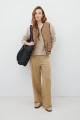 Buzo de punto con cuello redondo, manga larga y textura jaspeada en tonos beige y crema.