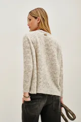 Sweater de punto con diseño calado geométrico, cuello redondo y mangas largas. Confeccionado en una mezcla de lana y alpaca, presenta una textura suave y ligera.