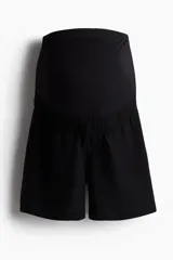 Short de maternidad color negro confeccionado en mezcla de lino y viscosa, de corte holgado con cintura ancha elástica diseñada para cubrir la barriga.