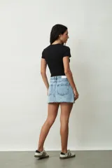 Minifalda de jean celeste con efecto lavado, tiro alto y ruedo desflecado.