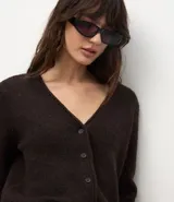 Cardigan de punto color marrón oscuro, con escote en V, cierre frontal con botones y mangas largas.